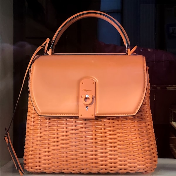 Orange woven wicker bag with a leather flap and top handle