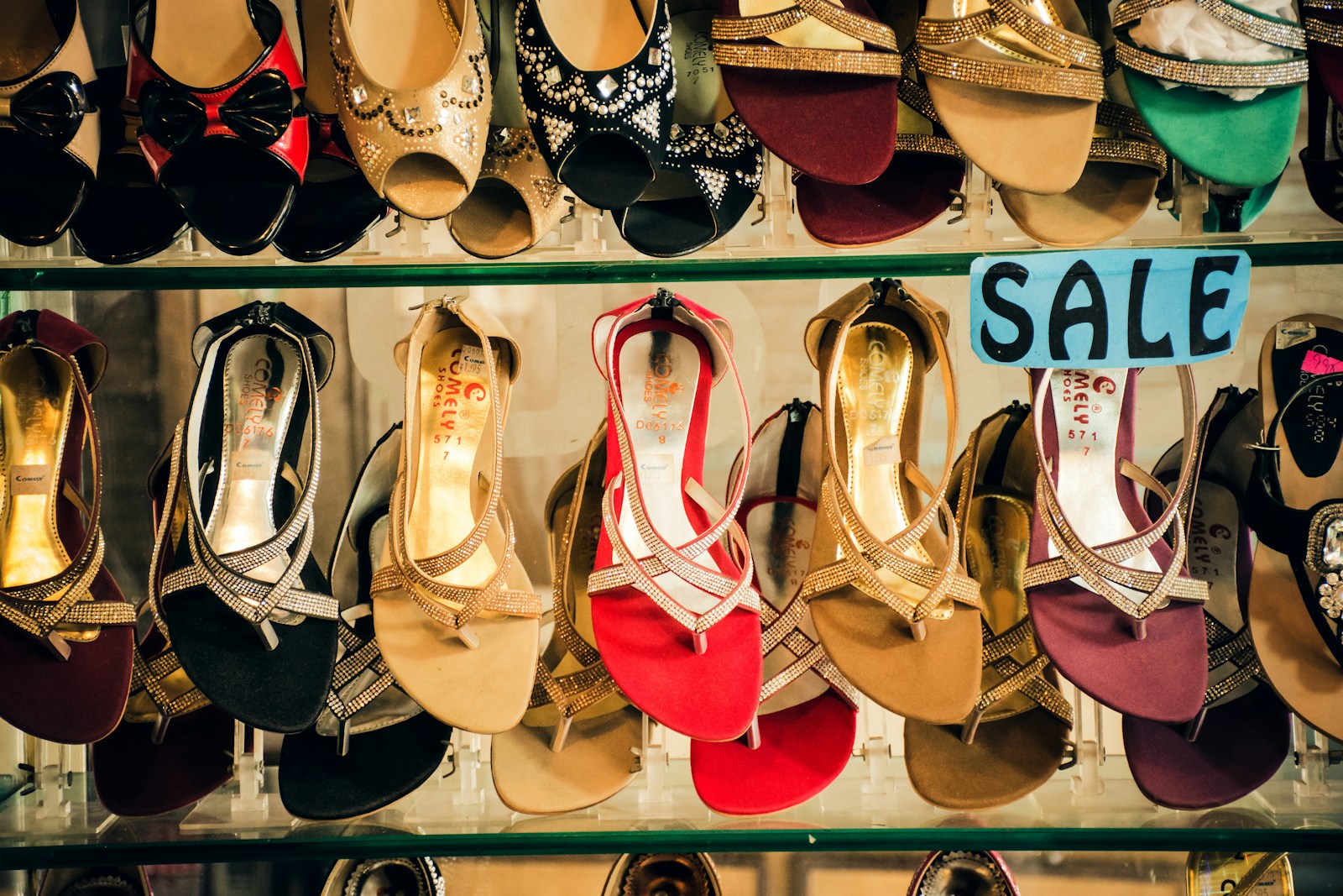 Sandals on shop shelves under a sale sign